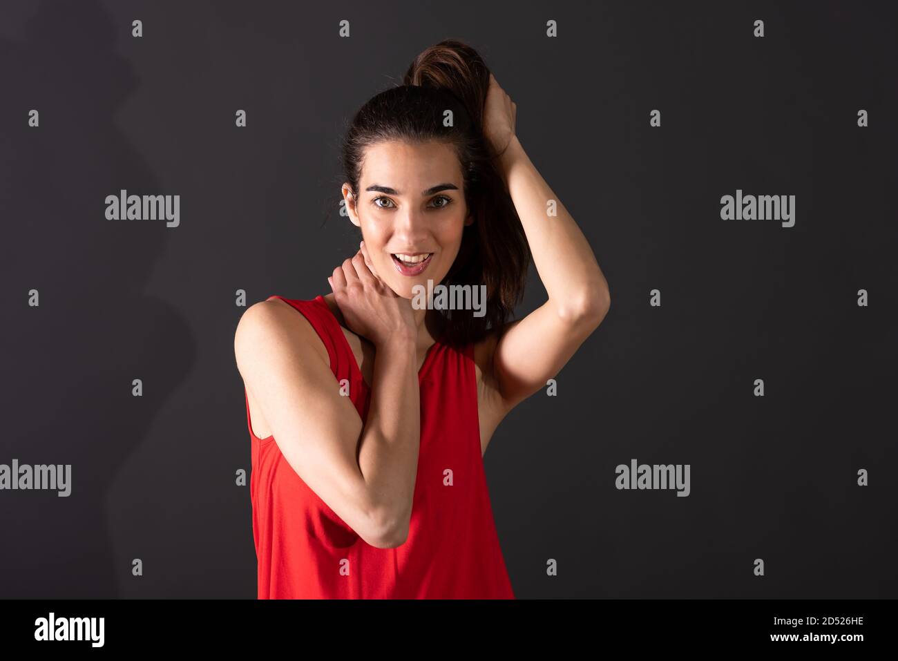 A beautiful smiling young woman in a red dress standing in front of a ...