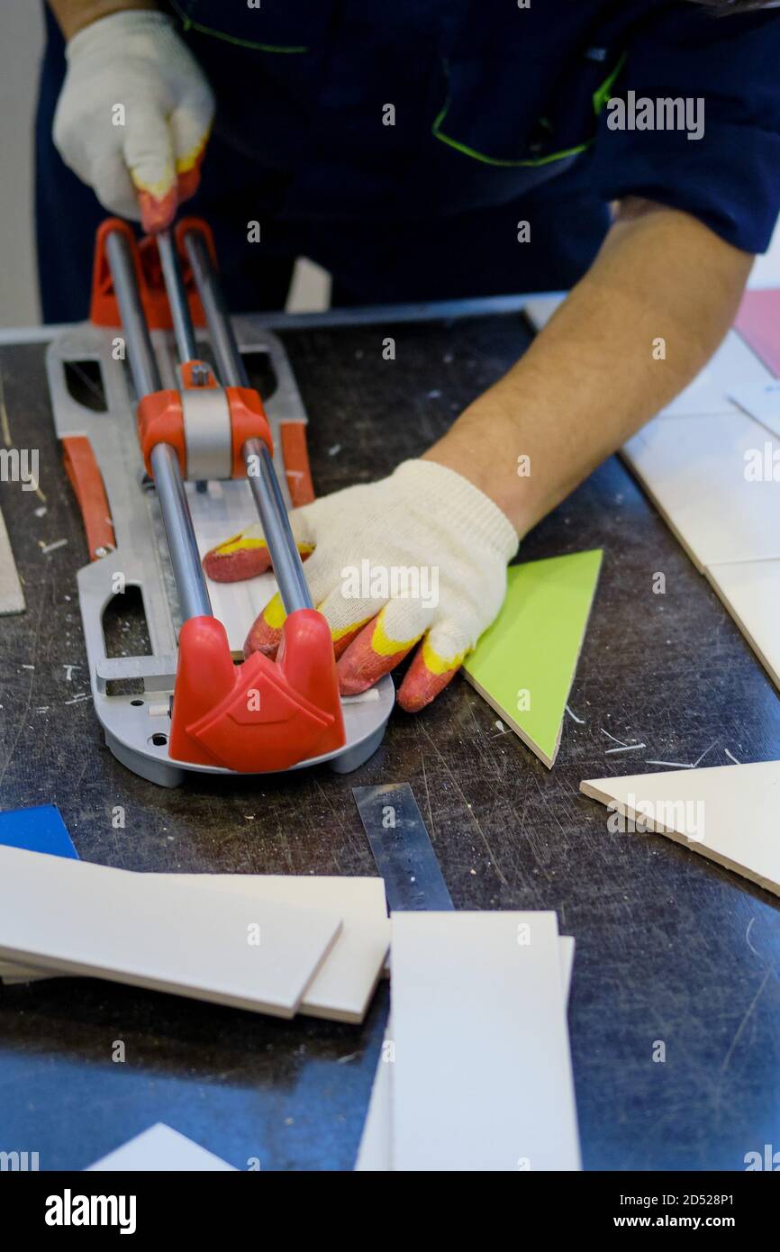 A man cuts a tile on the table, close-up Stock Photo