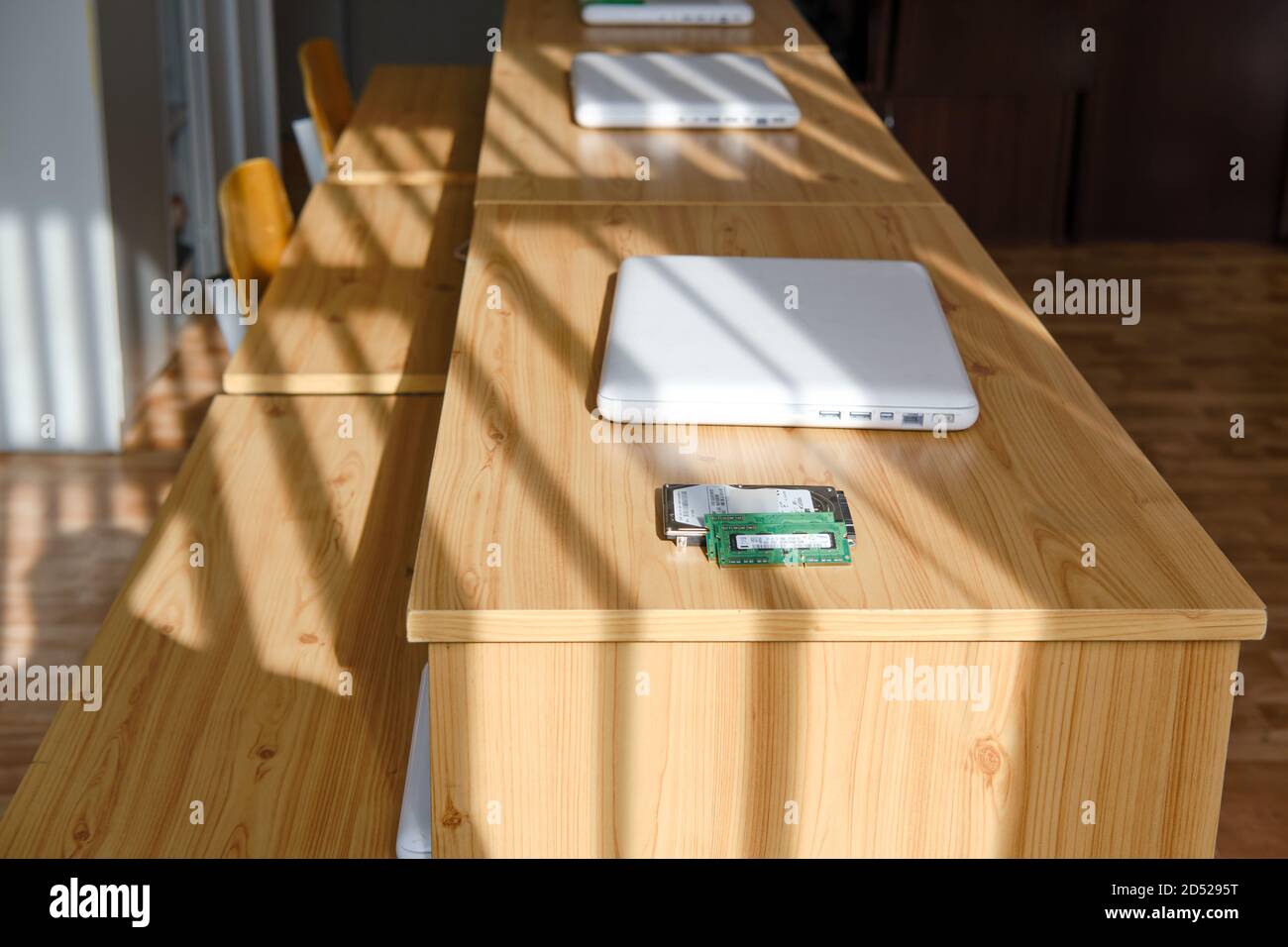 An empty computer science class and laptops are lying on the desks ...