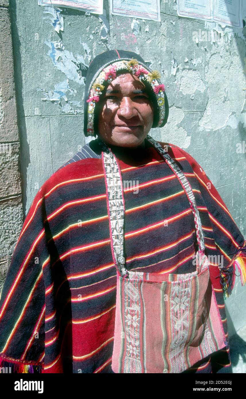 This Tarabuco indigenous textile vendor comes from a locality famed for its weaving. His leather hat imitates a conquistador's helmet, speaking volumes of the Spanish conquest almost 500 years ago. La Paz, capital of Bolivia. Stock Photo