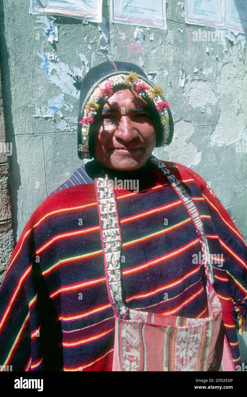 This Tarabuco indigenous textile vendor comes from a locality famed for its weaving. His leather hat imitates a conquistador's helmet, speaking volumes of the Spanish conquest almost 500 years ago. La Paz, capital of Bolivia. Stock Photo