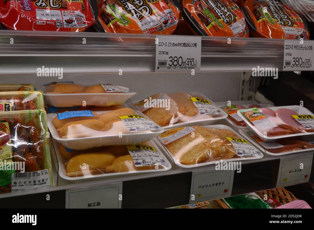 Tokyo, Japan-2/24/16: Inside a Japanese grocery store display of fresh refrigerated foods. Packages include hams, hash browns, noodles and corn dogs. Stock Photo