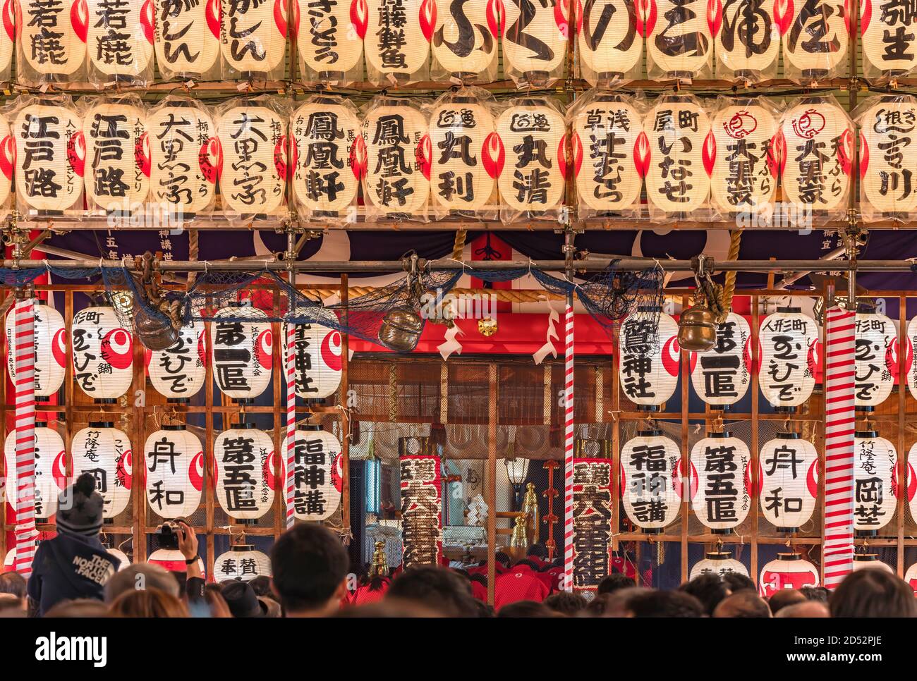 asakusa, japan - november 08 2019: Crowd of people waiting for make a wish by ringing the suzu bells of Ootori shrine decorated with luminous handwrit Stock Photo