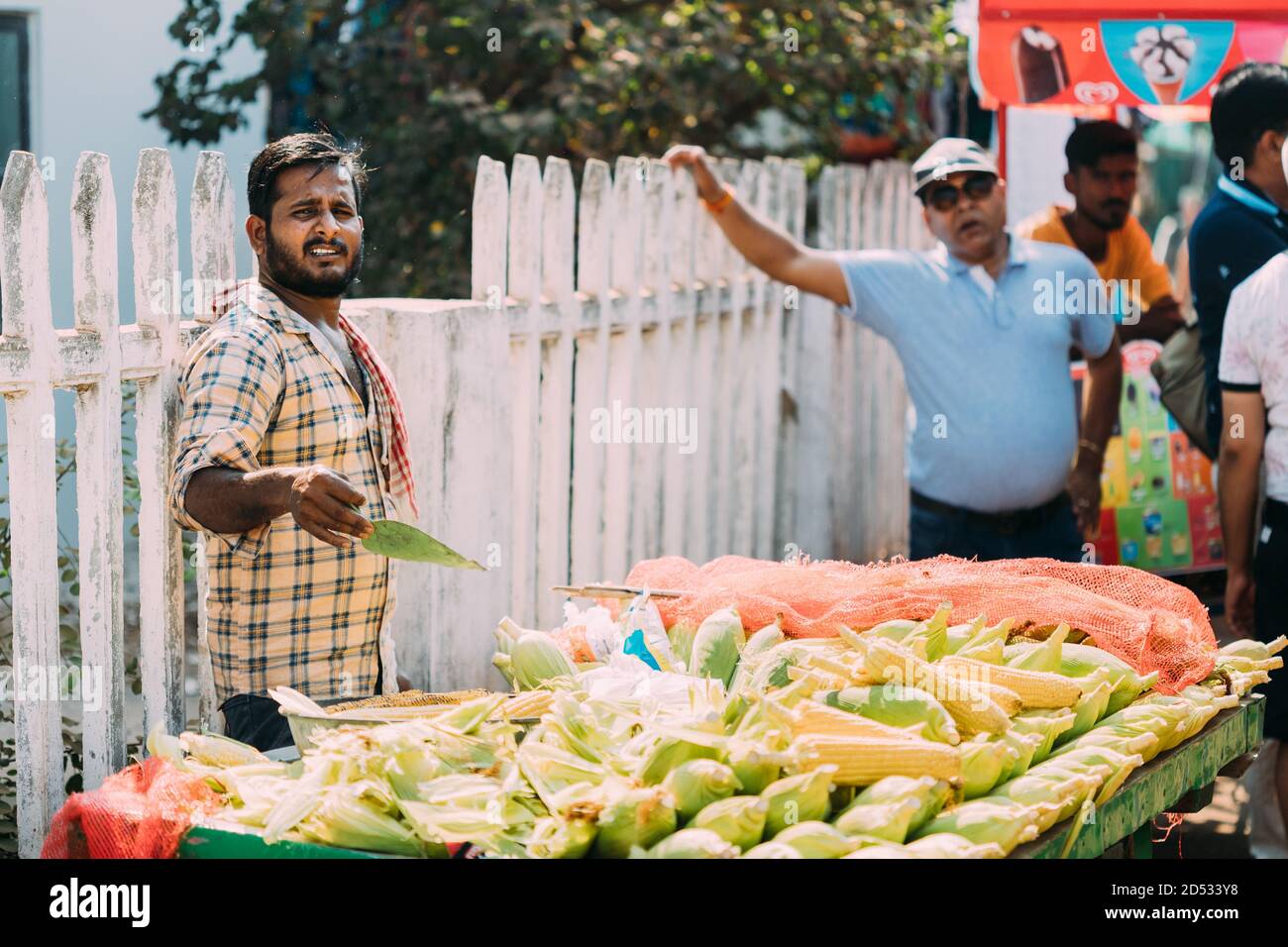 Anjuna, Goa, India. Man Seller Sells Traditional Indian Fried Maize Corn In The Anjuna Market Stock Photo