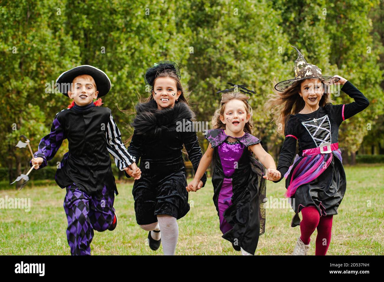Children in halloween costumes running on the lawn Stock Photo Alamy