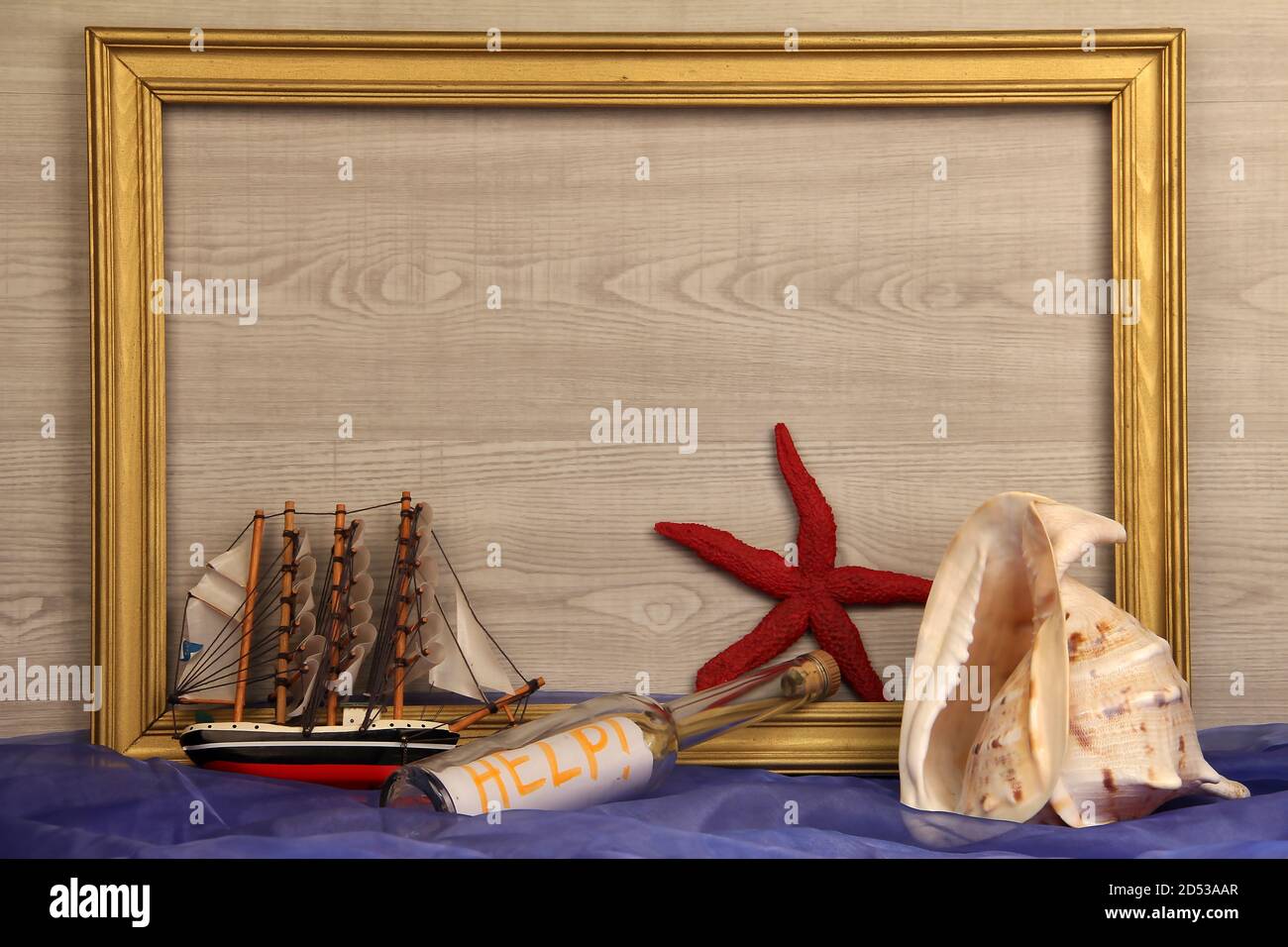 Closeup shot of a wooden frame, starfish, boat toy, seashell, and a ...