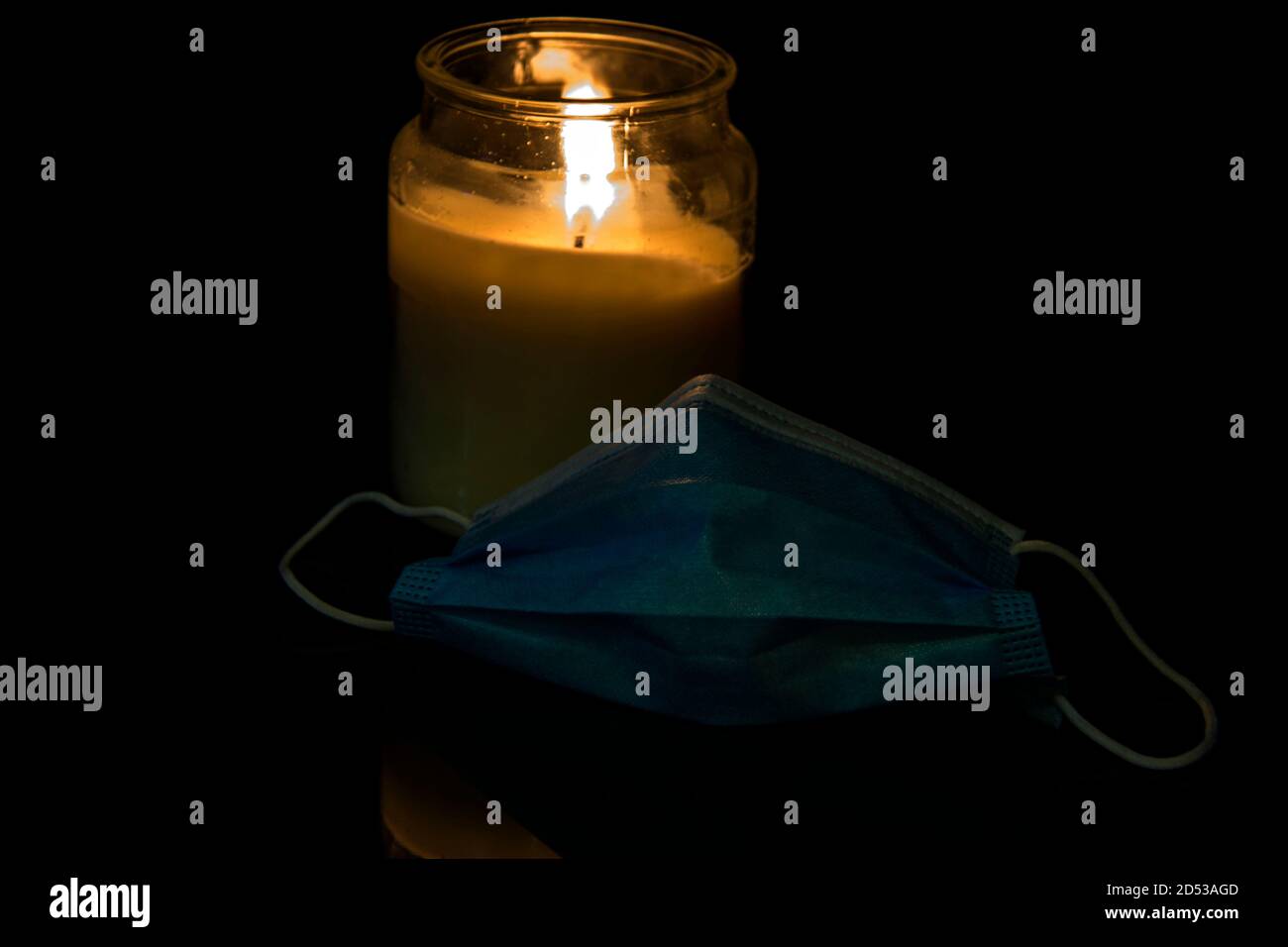 Burning candle and medical face mask Stock Photo Alamy