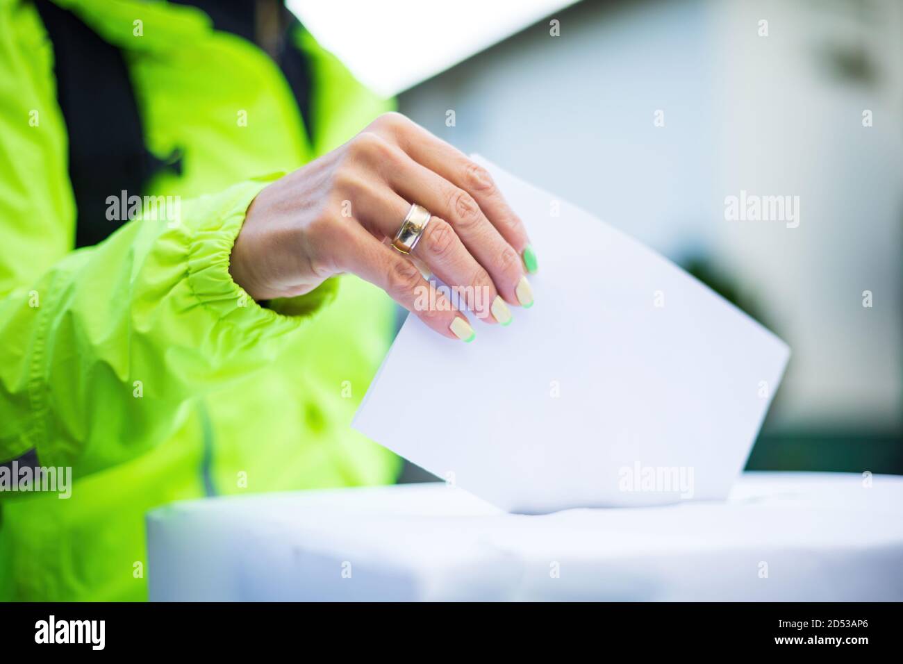 Womans hand voting at ballot box outside Stock Photo