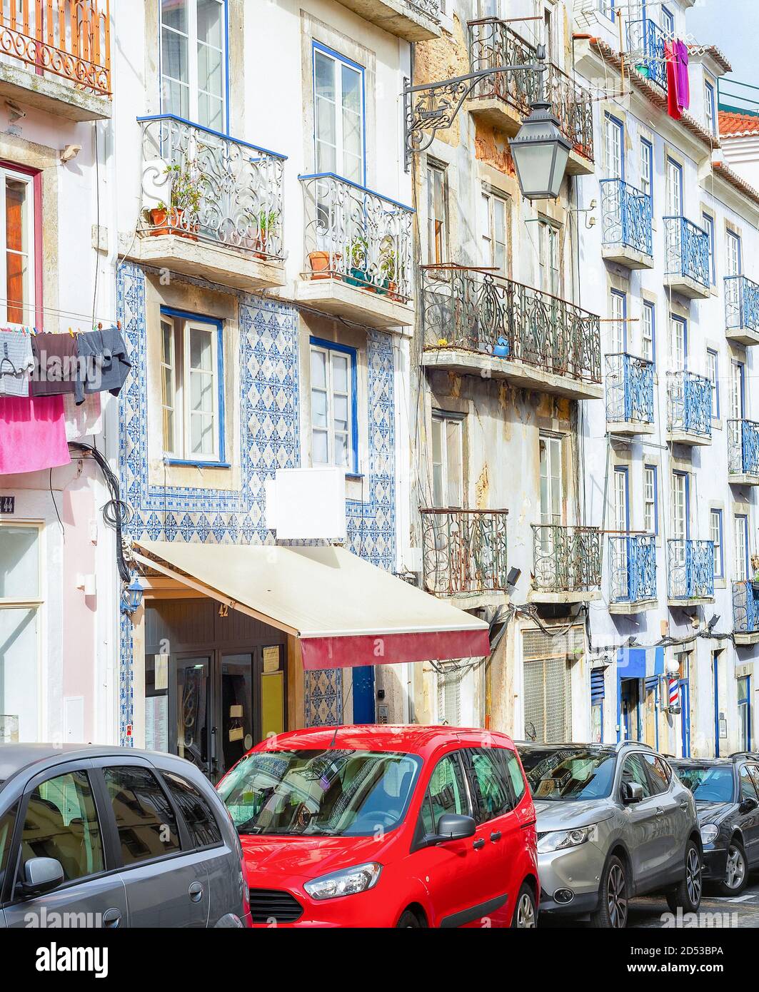 Typical portugese street with traditional tiled architecture, cars