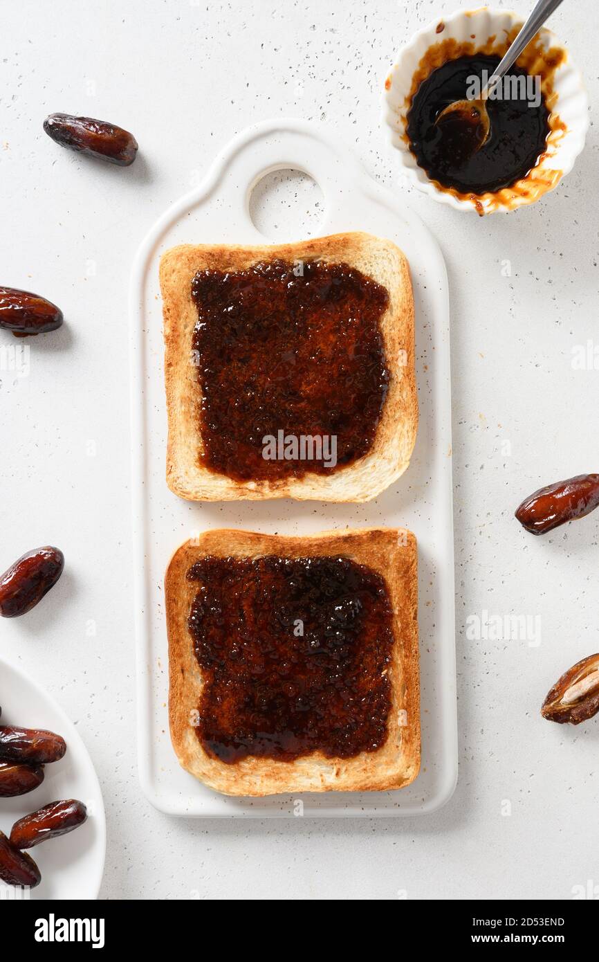Fresh toasts with dates jam without sugar on white table. View from above. Vertical. Stock Photo