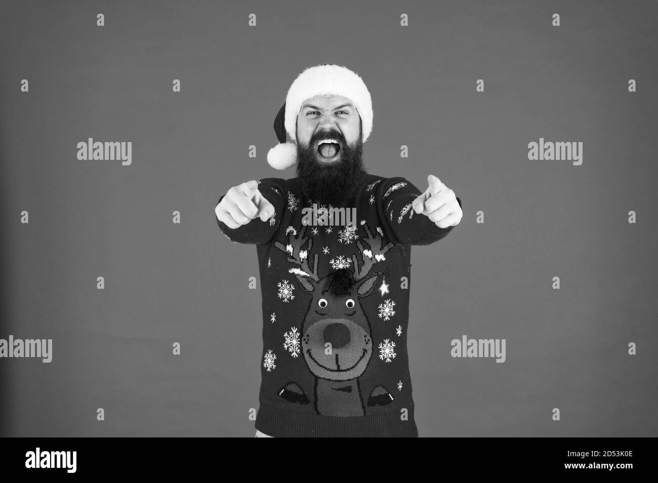 Start this party. Christmas celebration ideas. Happy new year celebration. Join holiday celebration. Winter party outfit. Sweater with deer. Hipster bearded man wear winter clothes red background. Stock Photo