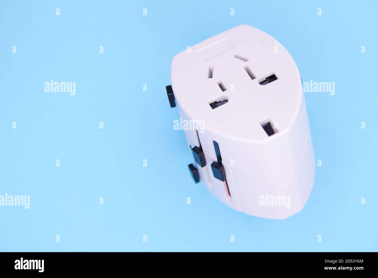 adapter electric adapter multifunctional white on a blue background. Stock Photo