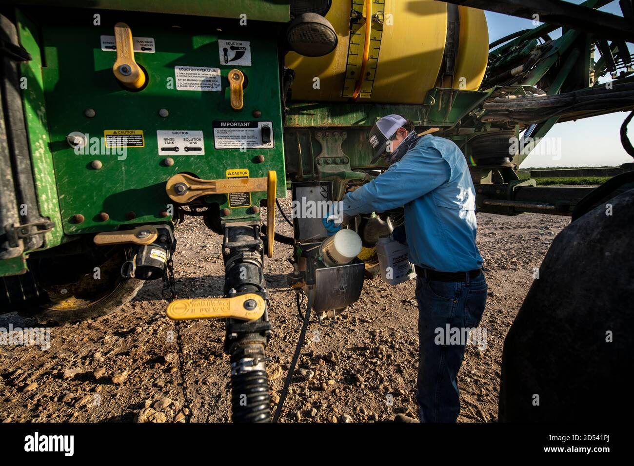 Operations Manager Brandon Schirmer loads defoliant chemicals into his sprayer to prepare a cotton field for harvest at his family farm August 12, 2020 in Batesville, Texas. Stock Photo