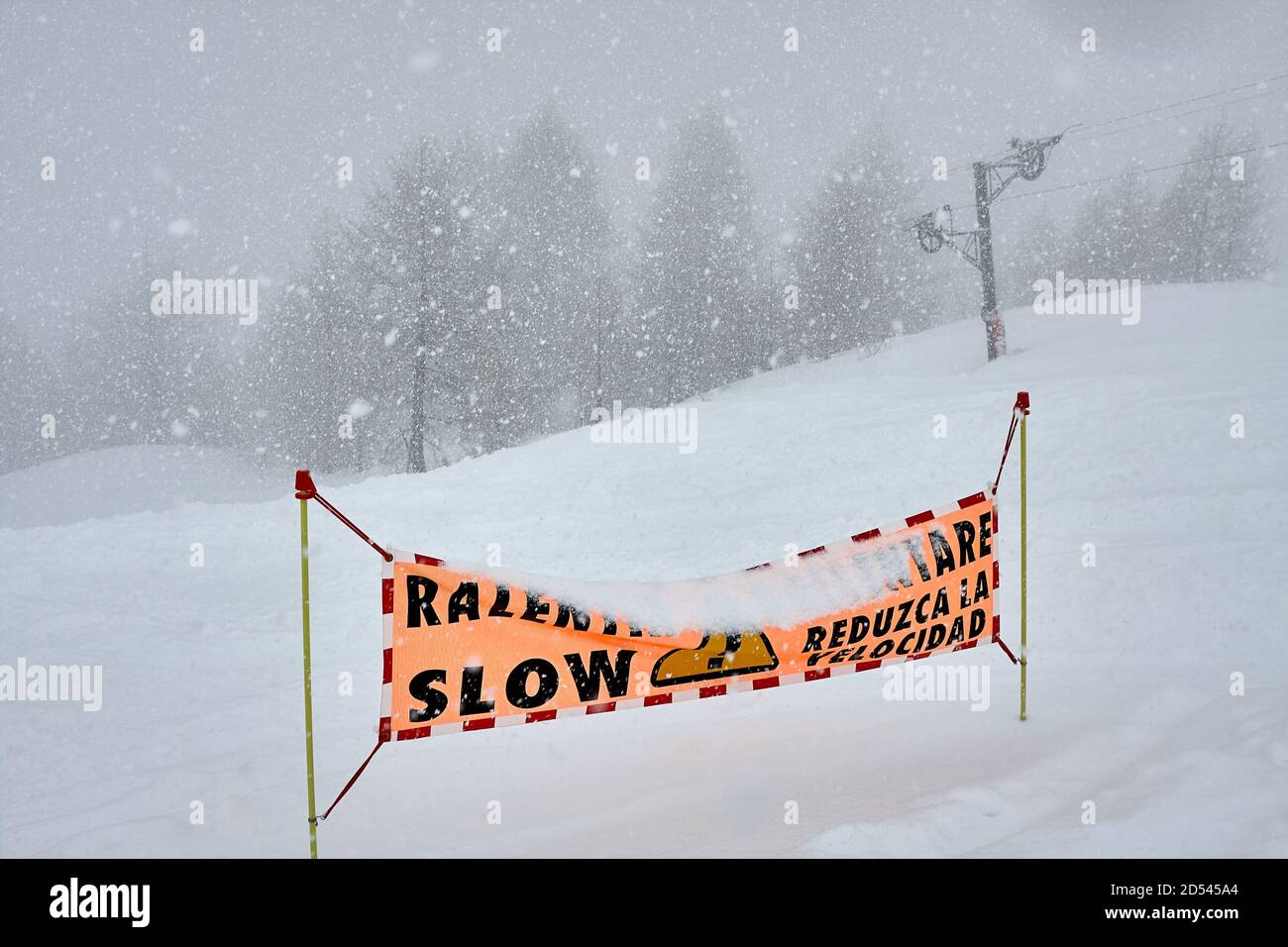 Ski slop warning sign in heavy snowing Stock Photo