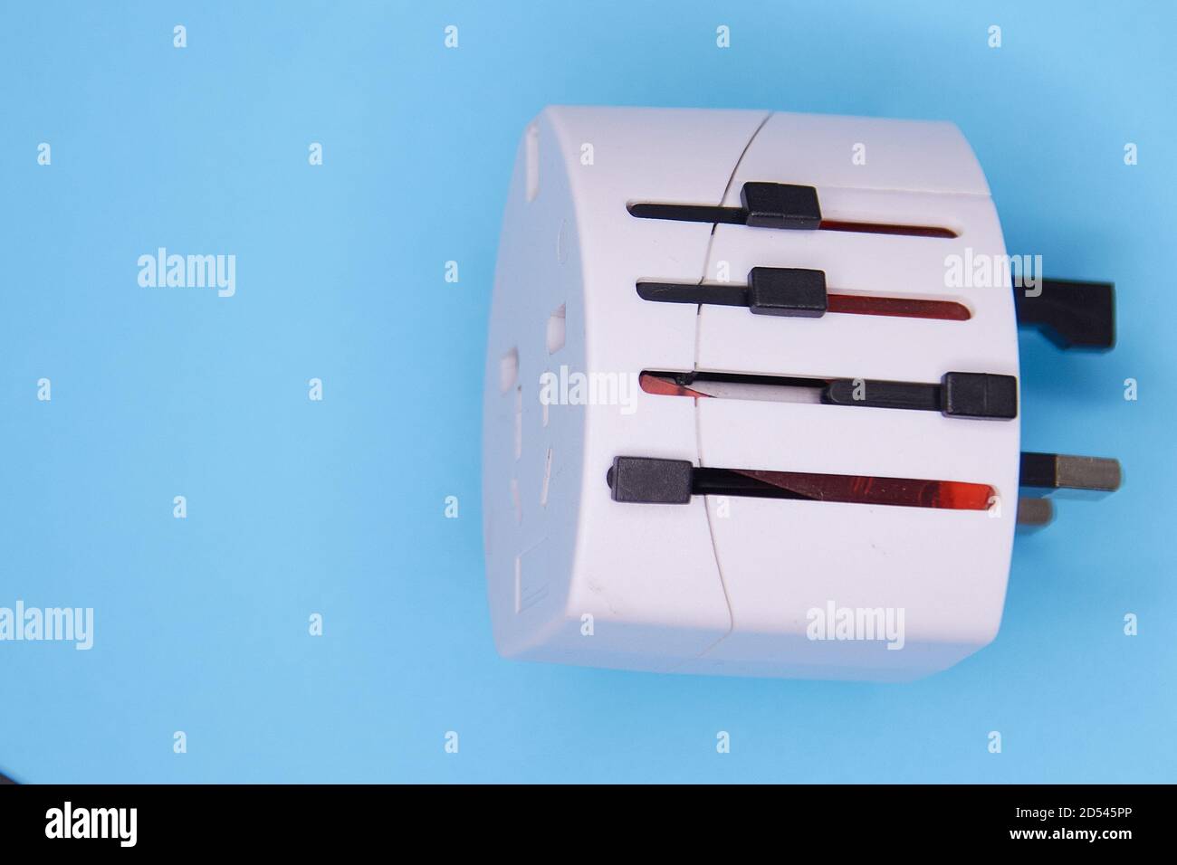 adapter electric adapter multifunctional white on a blue background. Stock Photo