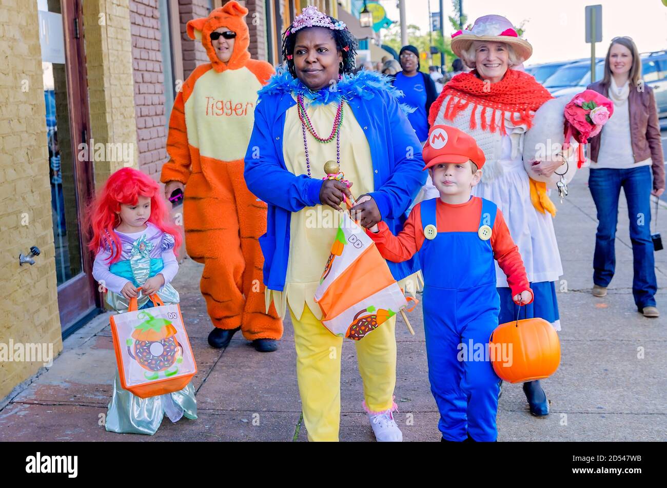 Children, by adults in costume, trickortreat at downtown