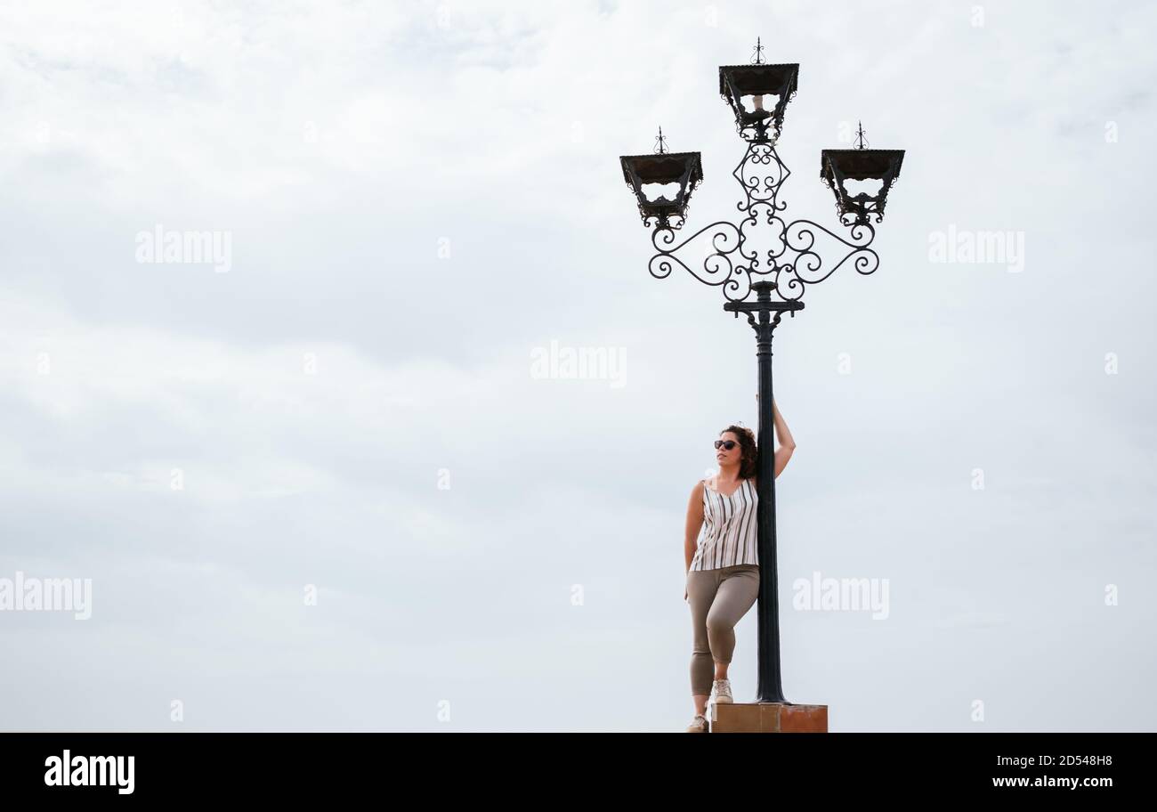 Caucasian woman leaning on a lamppost Stock Photo