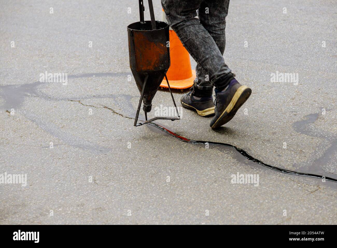 Sealing joint crack in asphalt road surface restoration work asphaltic