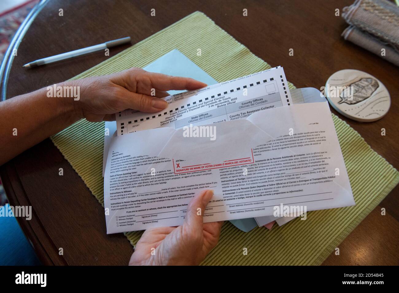 Austin, Texas, October 12, 2020: Woman encloses her completed mail-in absentee ballot into the provided official envelope. The form must to be either mailed back or dropped off in person in time to be counted before the November 3rd election day. Stock Photo
