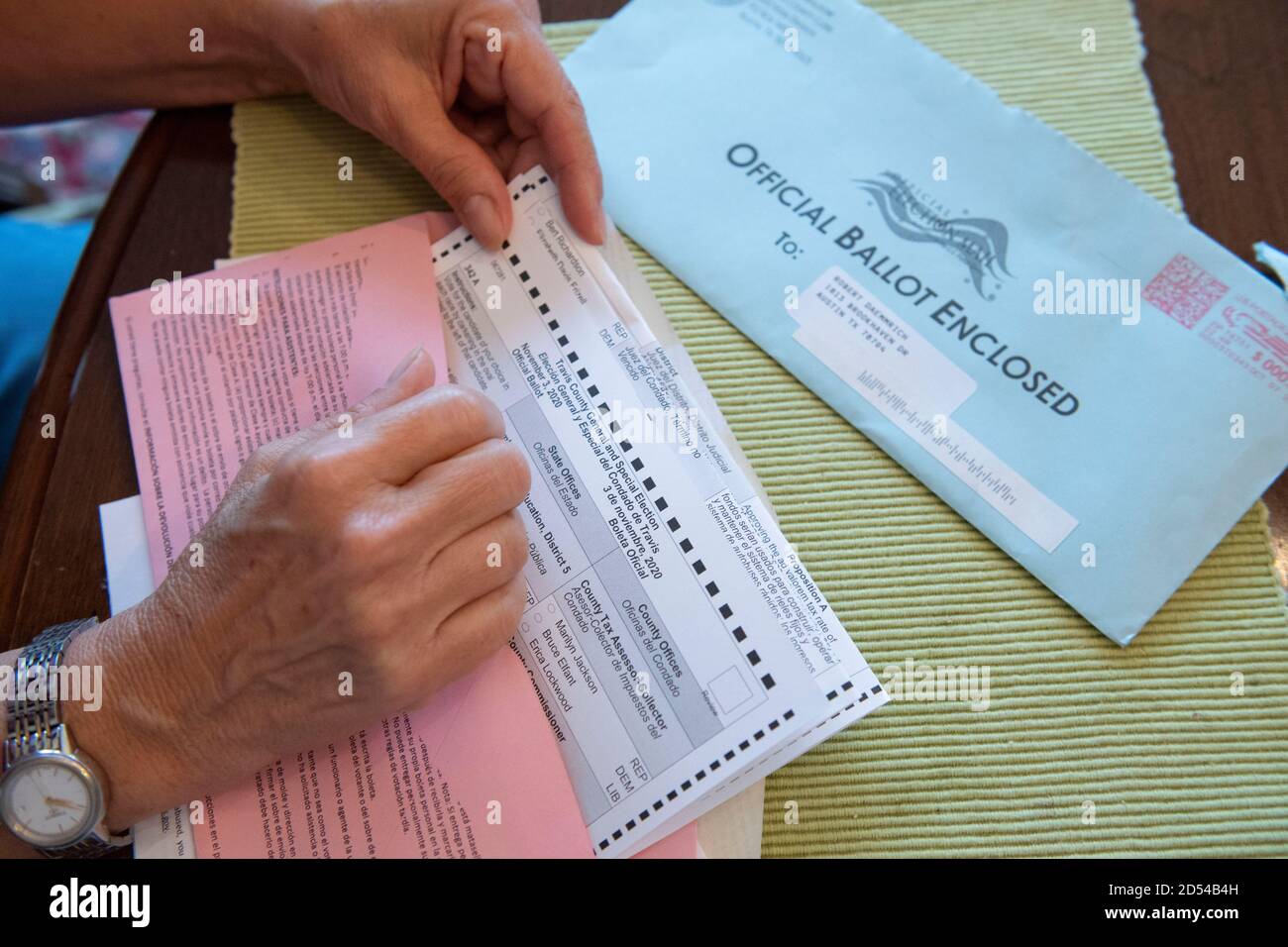 Austin, Texas, October 12, 2020: Woman encloses her completed mail-in absentee ballot into the provided official envelope. The form must to be either mailed back or dropped off in person in time to be counted before the November 3rd election day. Stock Photo