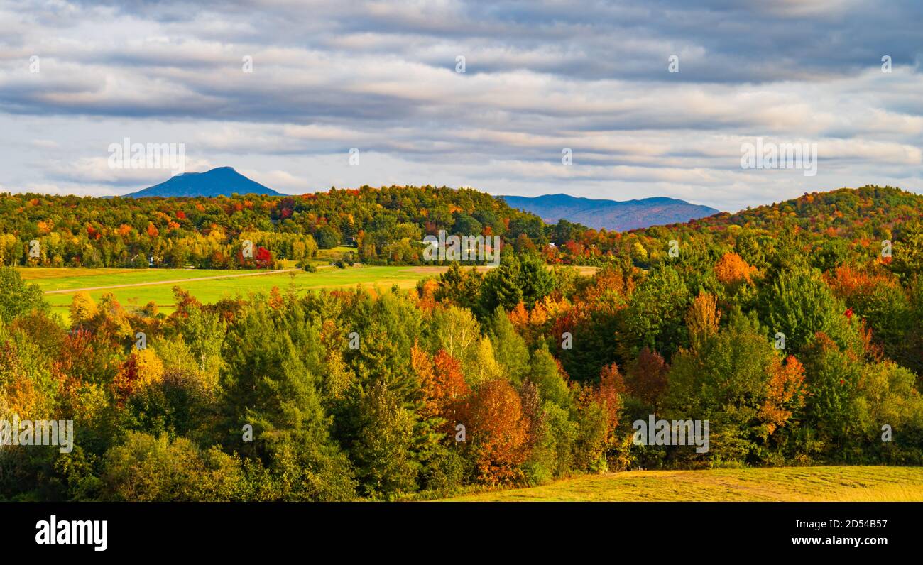 view of rural farm fields and forests  with Camels Hump Mountain in fall foliage season, in Vermont Stock Photo