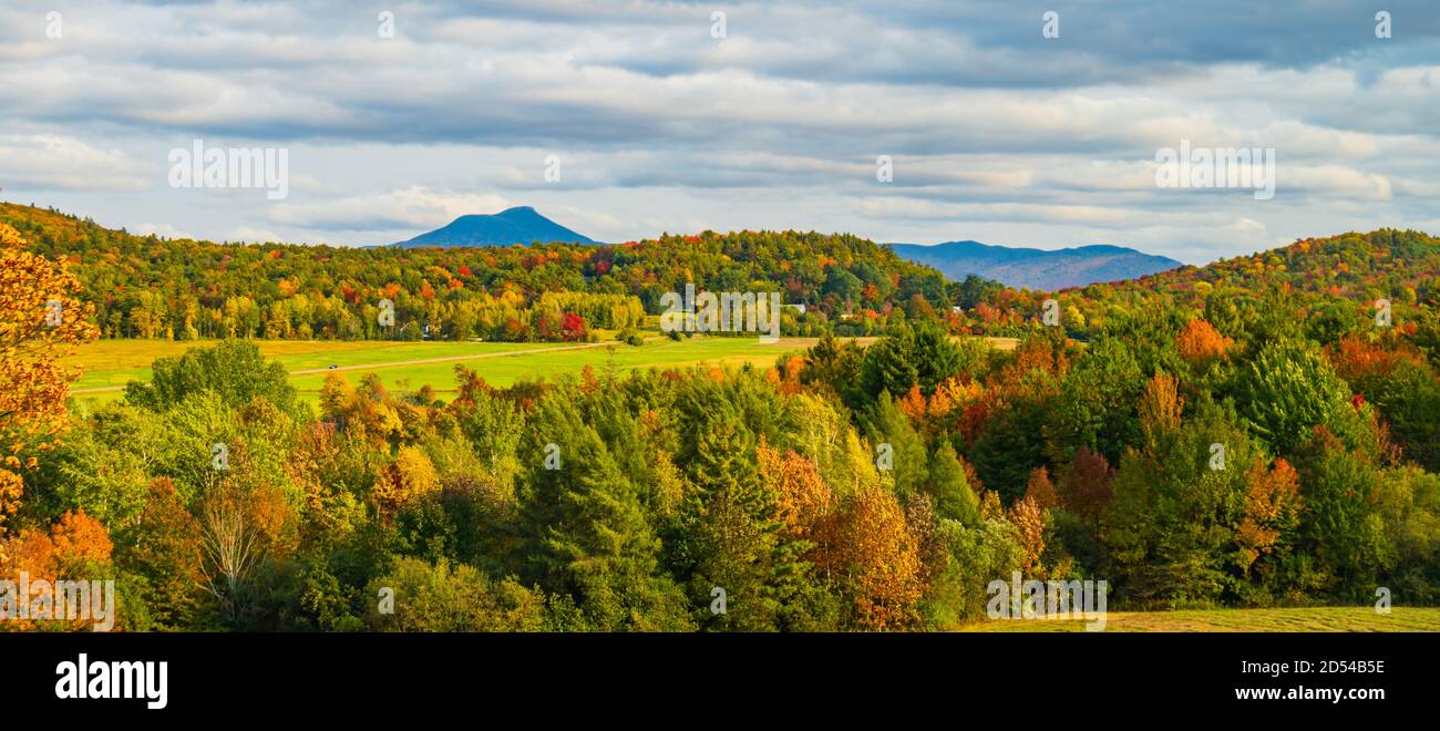 view of rural farm fields and forests  with Camels Hump Mountain in fall foliage season, in Vermont Stock Photo