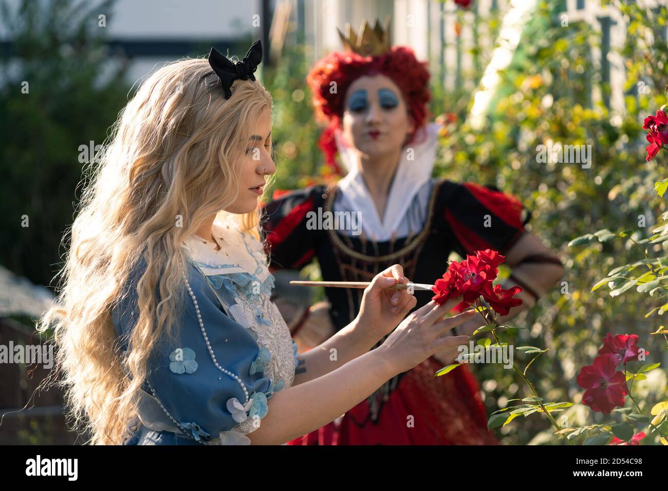 MUNICH, GERMANY - Sep 12, 2020: Cosplayer as characters from Alice in Wonderland. paints red roses and is observed the queen Stock Photo - Alamy