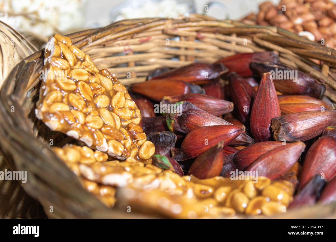 Wicker basket with typical Brazilian foods. June party foods. Pine nuts, rapadura, peanuts, popcorn, green corn. Popular celebrations. Goodies and typ Stock Photo