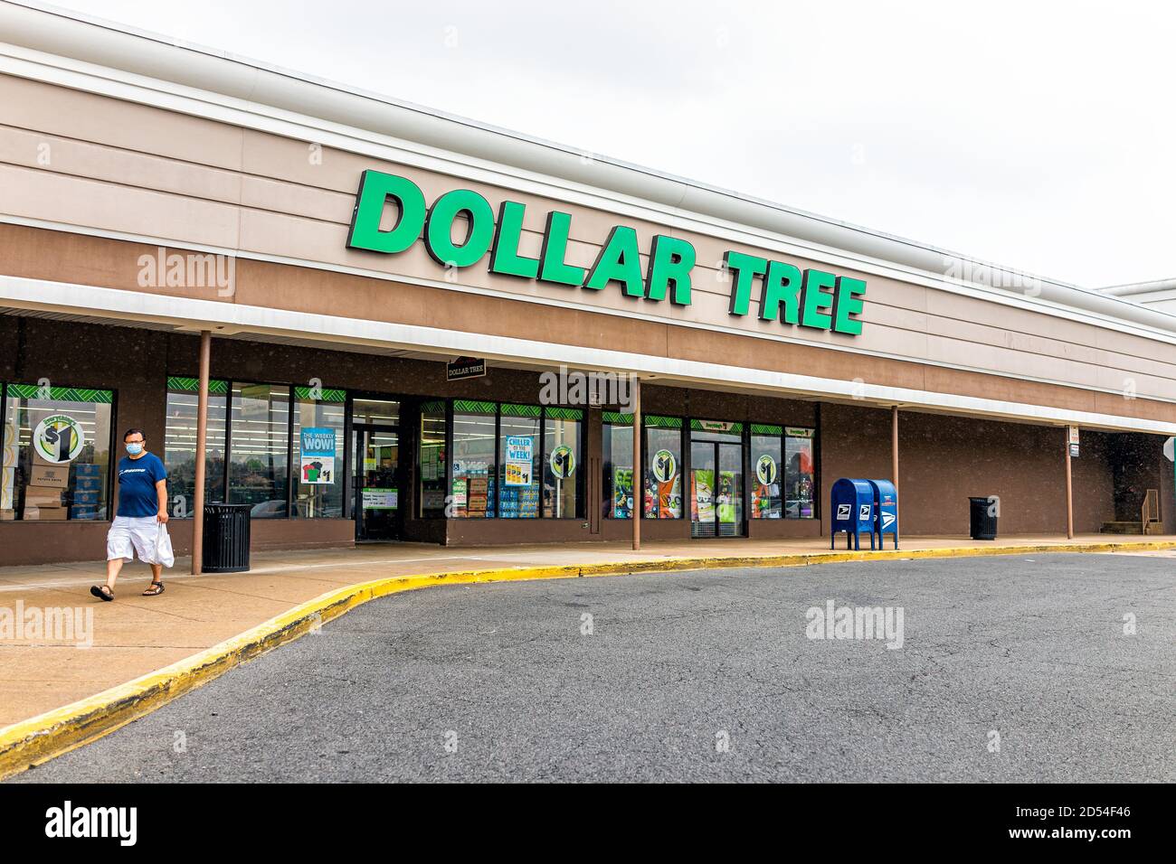 Sterling, USA - September 9, 2020: Storefront sign at strip mall plaza with people man person in mask walking by entrance to dollar tree during Covid- Stock Photo