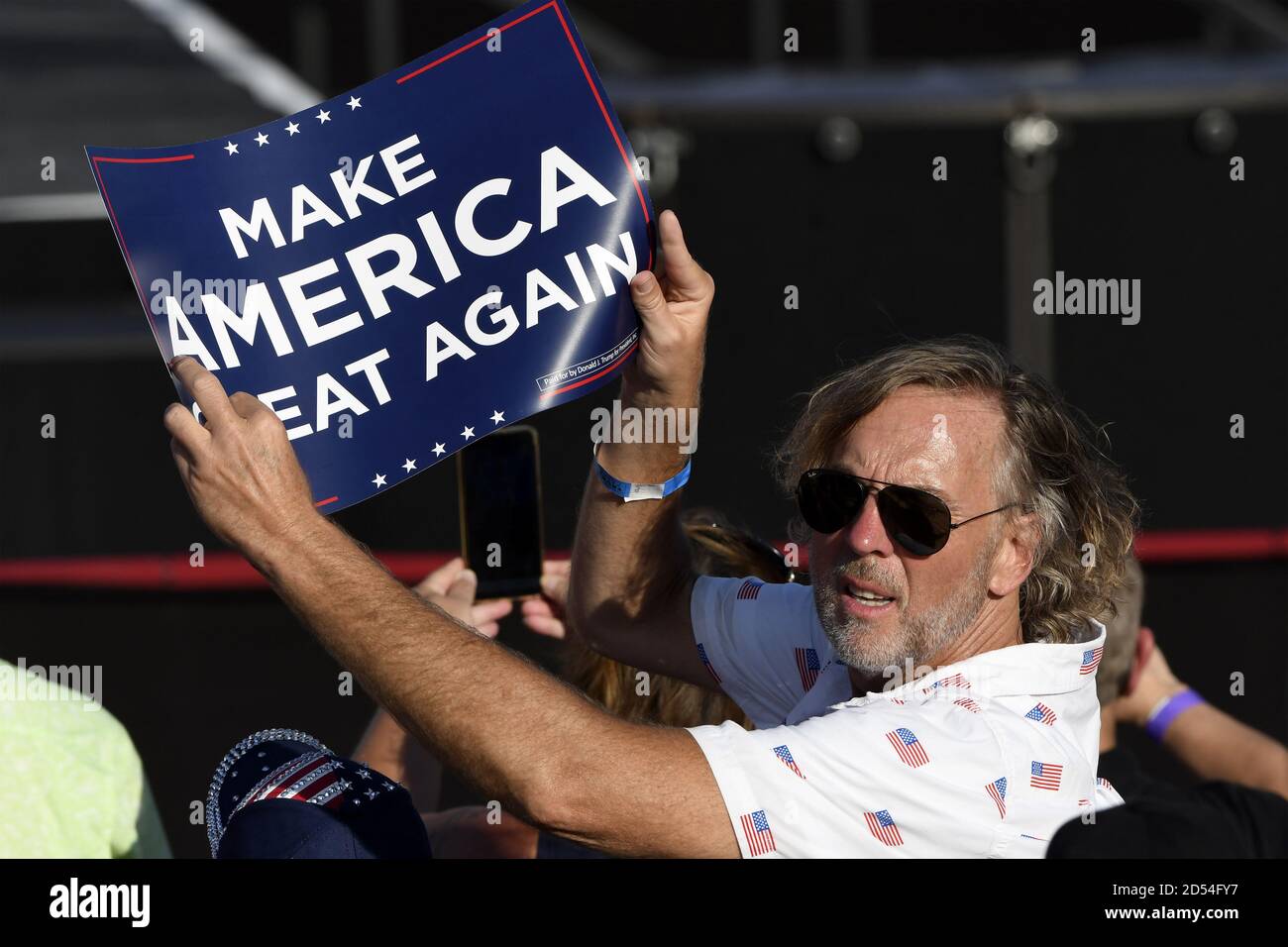 Sanford, United States. 12th Oct, 2020. Central Floridia holds up a 'Make America Great again' poster as he attends the rally held by President Donald Trump in Sanford, Florida on Monday, October 12, 2020. This is the president's first rally since being diagnosed with Covid-19. Photo by Joe Marino/UPI Credit: UPI/Alamy Live News Stock Photo