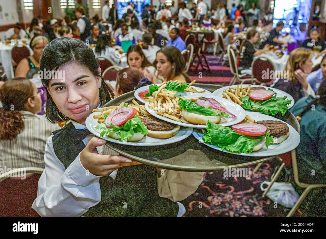 Miami Florida,Marriott Dadeland Hotel ballroom,student conference luncheon,Hispanic woman female waitress server serving,lunch holds holding tray plat Stock Photo