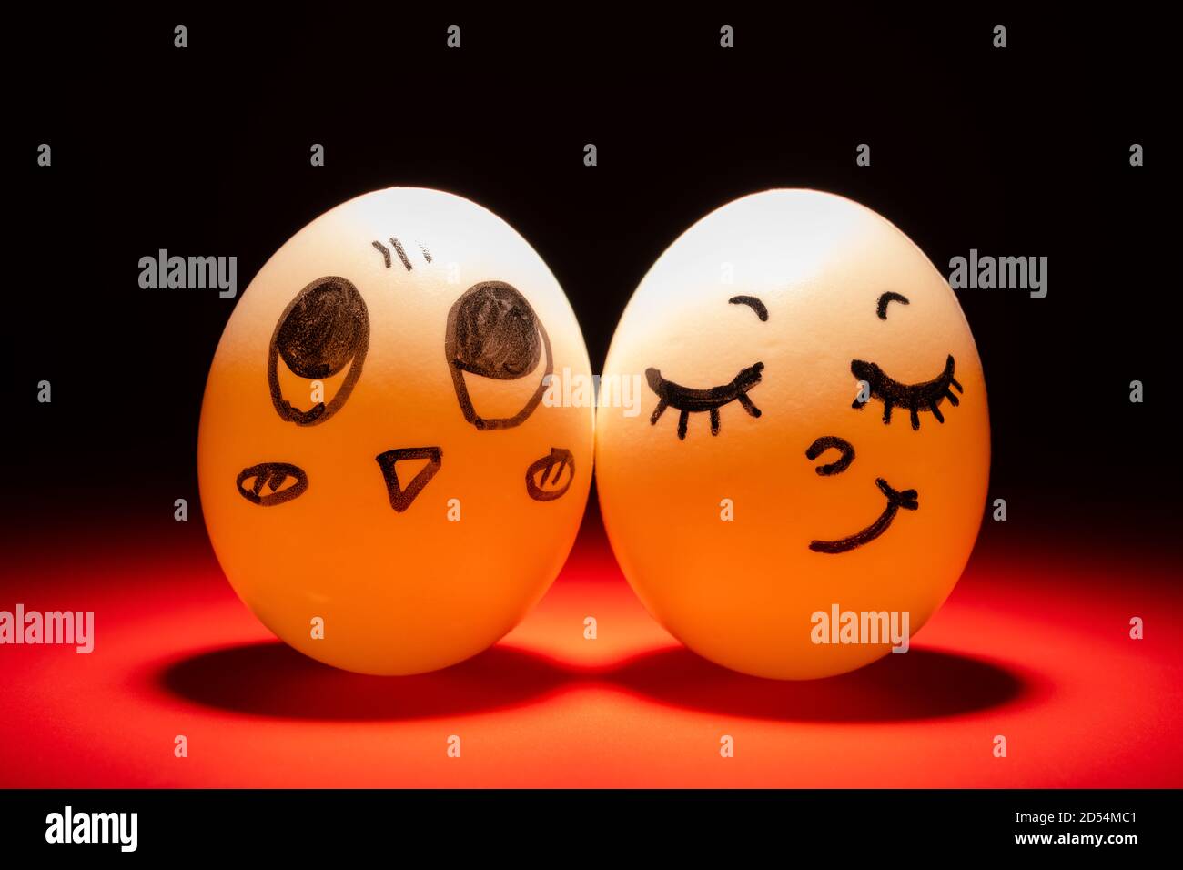 egg faces of lovely couple highlighted in dark Stock Photo