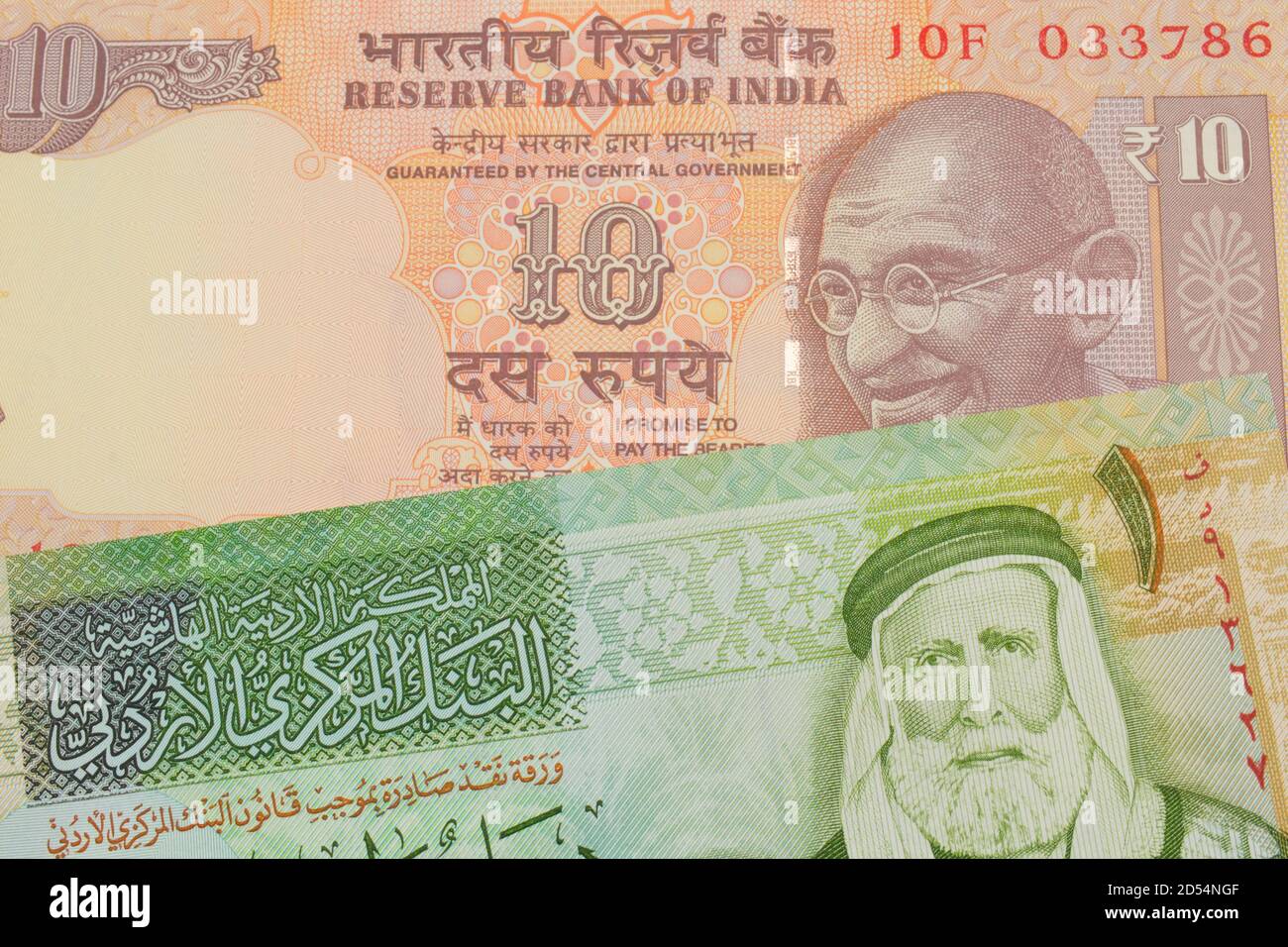 A macro image of a orange ten rupee bill from India paired up with a green  and yellow one dinar note from Jordan. Shot close up in macro Stock Photo -  Alamy