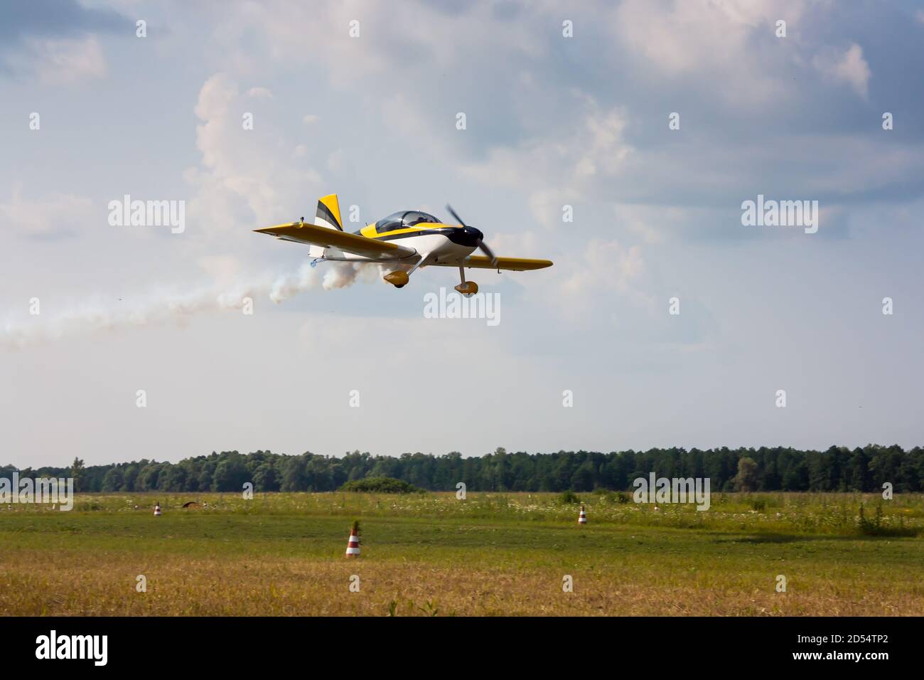 Low pass of a small sports plane with smoke Stock Photo