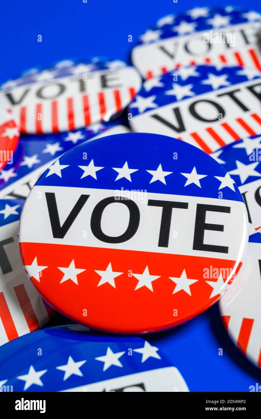 A group of red, white and blue VOTE button on a blue background Stock Photo
