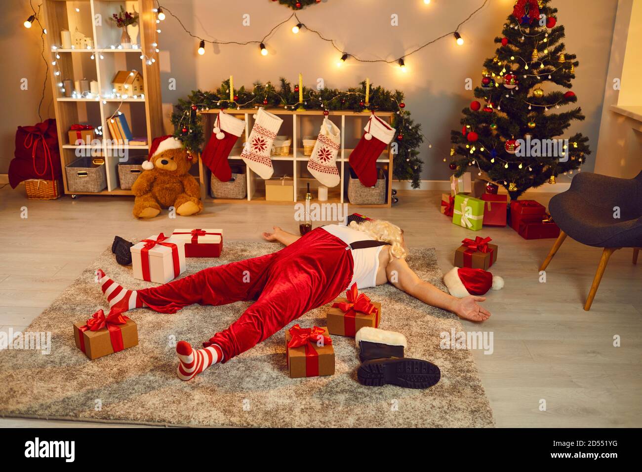 Drunk or overworked Santa sleeping on floor after night of Christmas parties and delivering presents Stock Photo