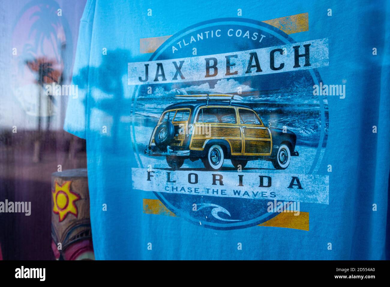 Jax Beach surfing t-shirt seen through the storefront window of an oceanfront souvenir shop along the boardwalk at Jacksonville Beach, FL. (USA) Stock Photo