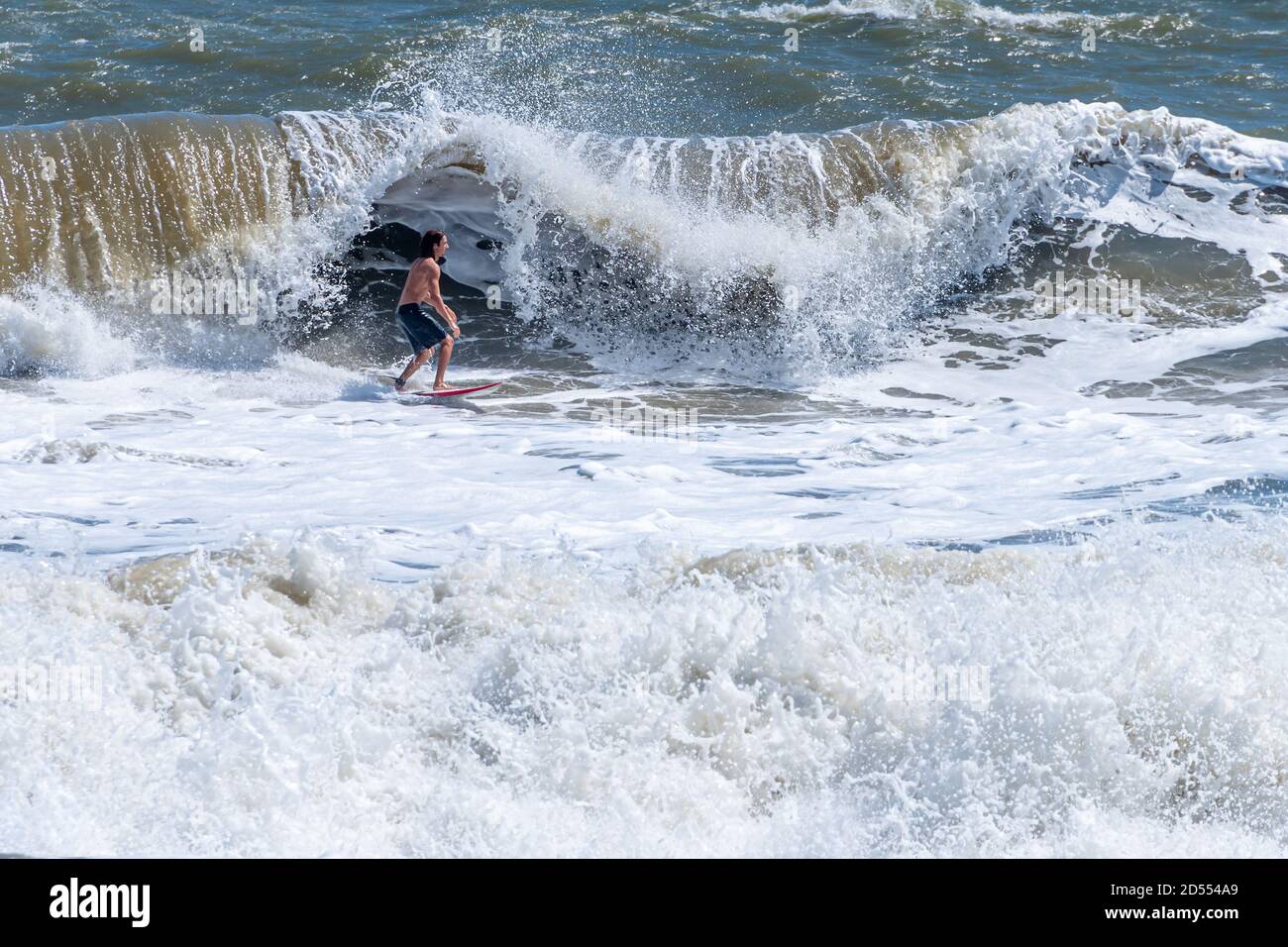 The combination of a Nor'easter and Hurricane Teddy swells produced overhead waves for adventurous surfers at The Poles in Jacksonville, Florida. Stock Photo