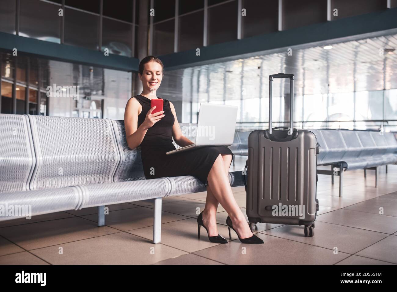 Business woman managing tasks while waiting for a flight Stock Photo
