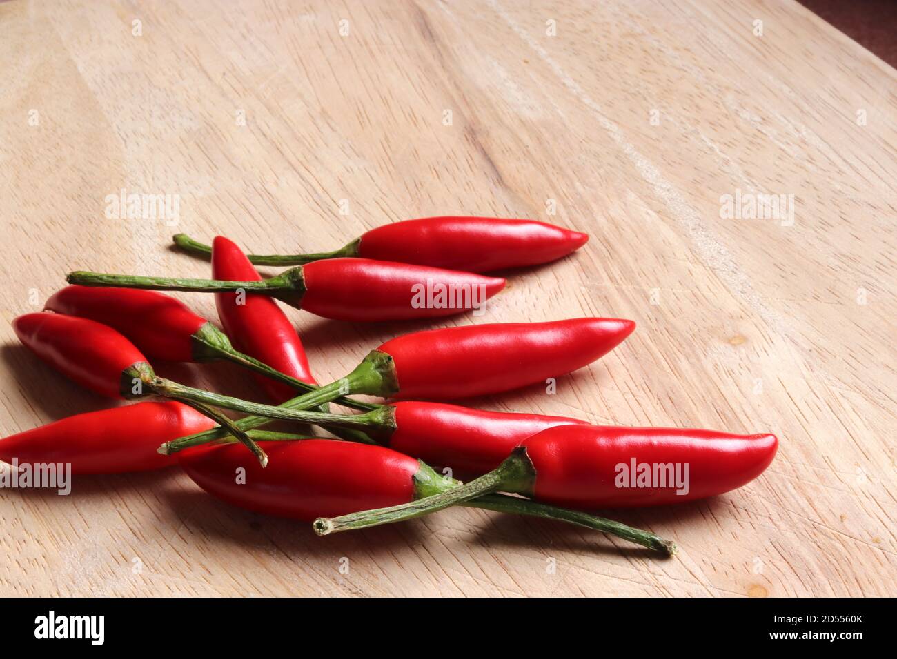 Birds Eye Chilli's on a wooden chopping board Stock Photo - Alamy