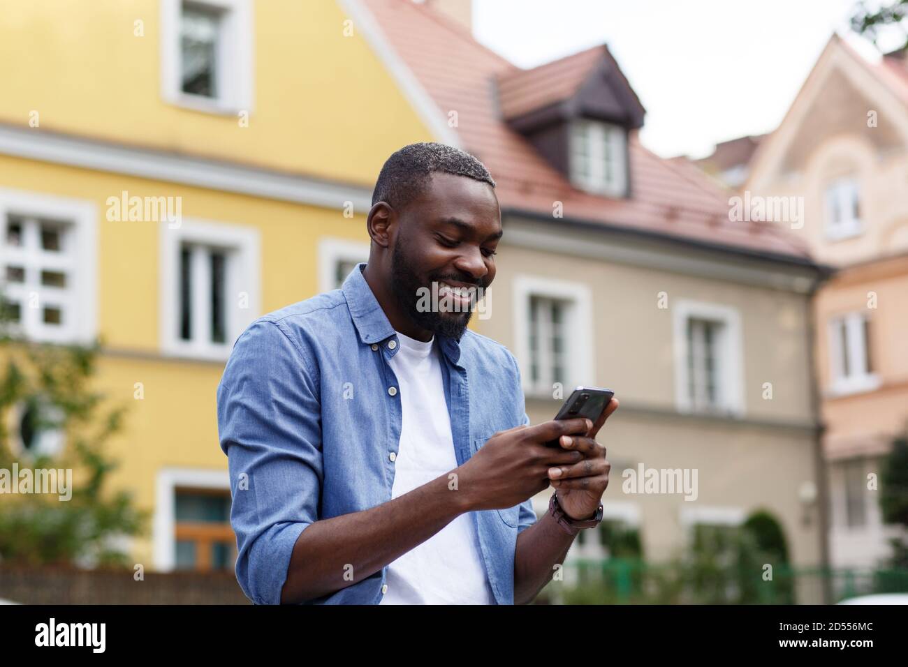 Handsome Afro-American man using smartphone and smiling. Happy man ...