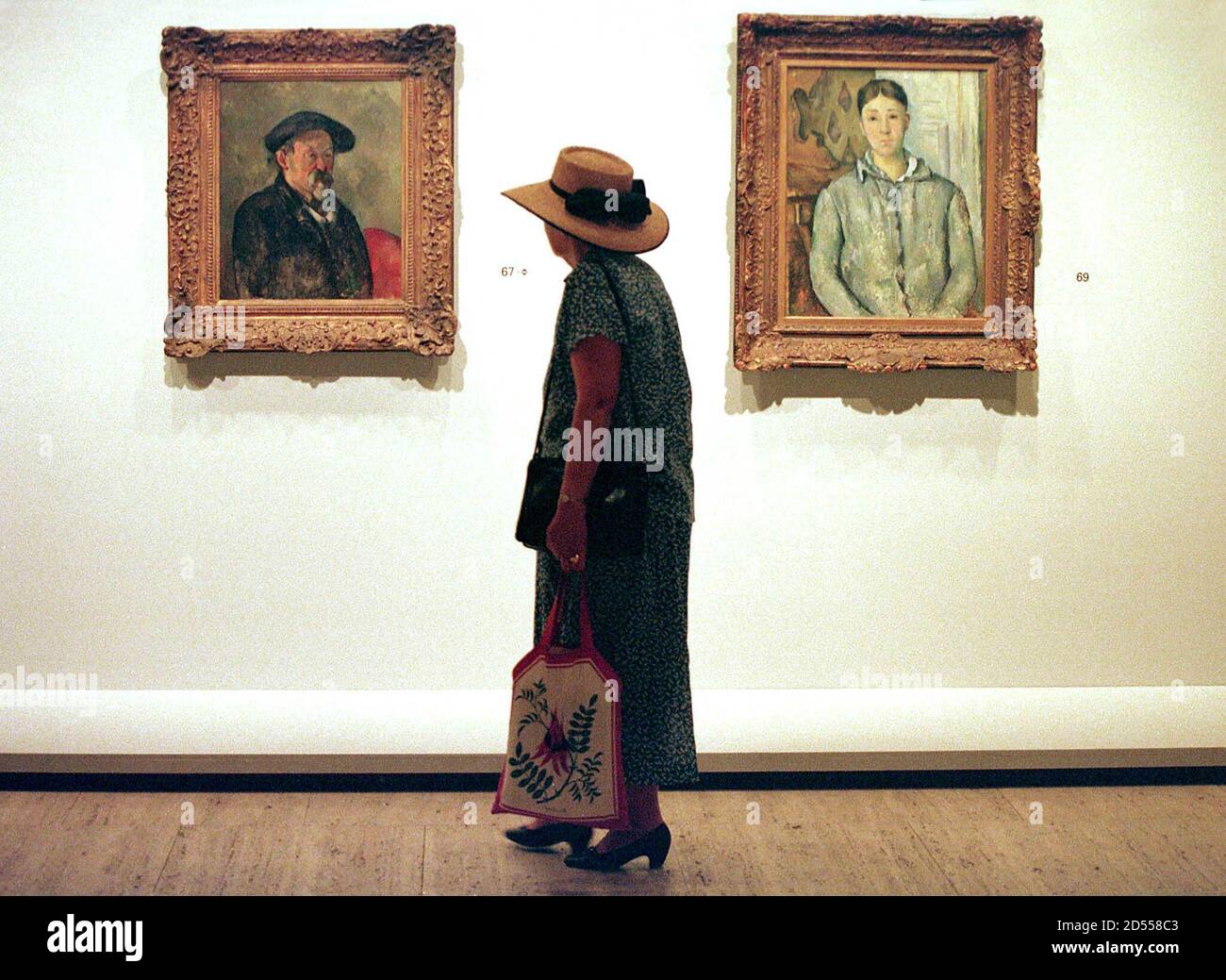 Download A Lady Wearing A Hat Looks At Two Paintings By French Artist Paul Cezanne At New South Wales Art Gallery In Sydney November 27 During The Launch Of The First Solo Exhibition