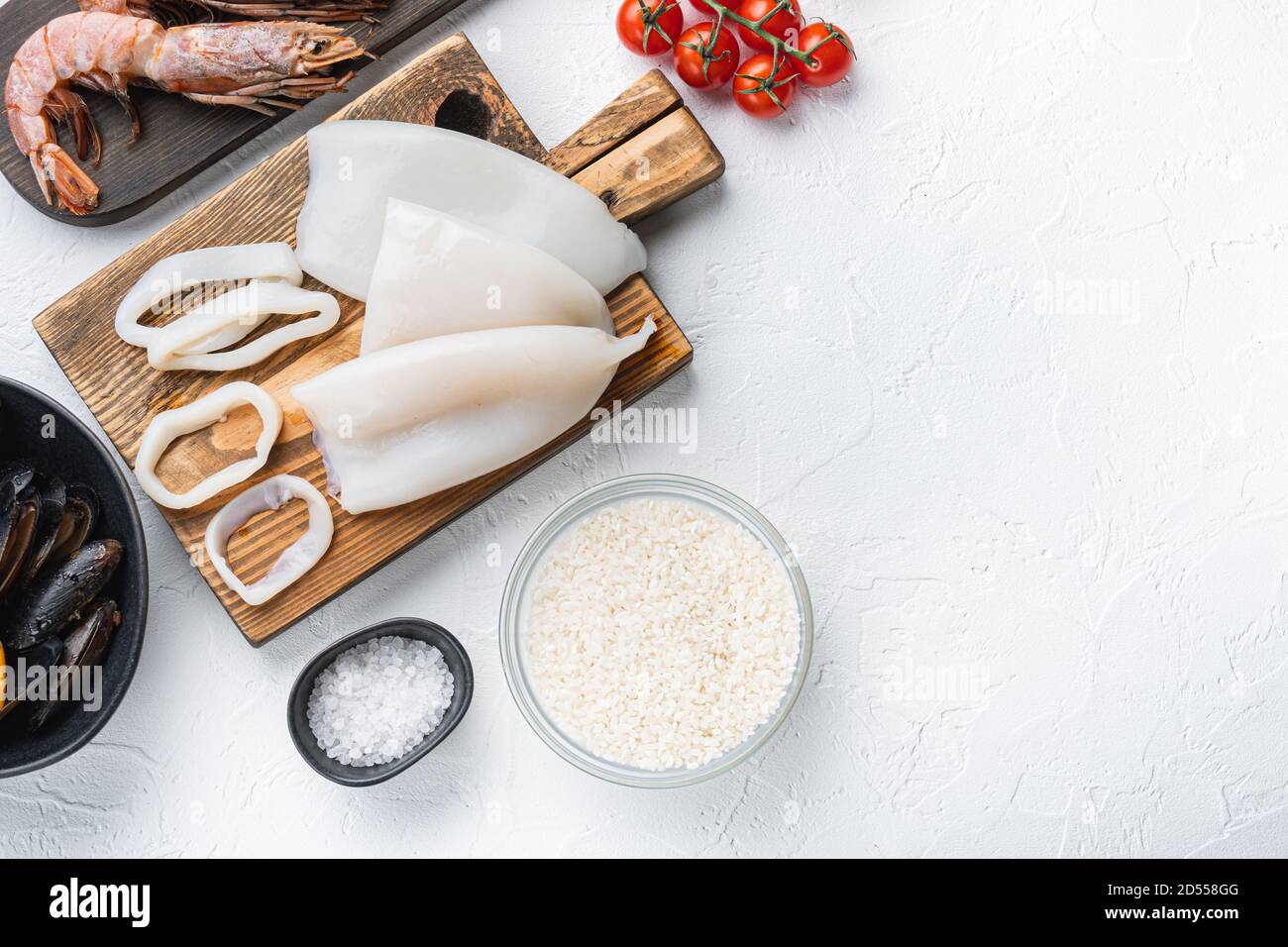 Raw ingredients for paella with seafood on white background, top view with space for text Stock Photo