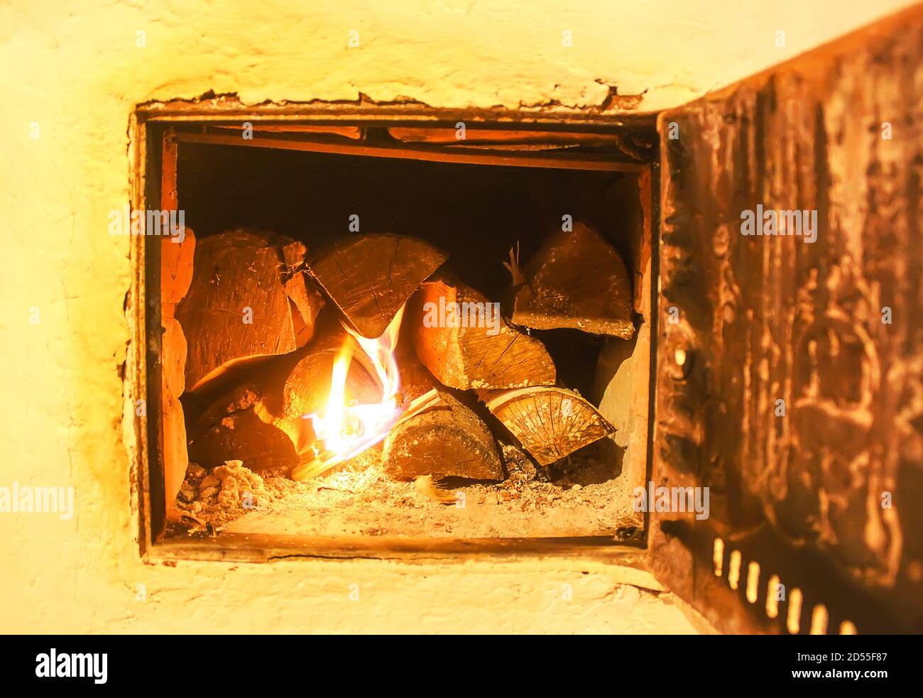 Warm light of a burning bright fire in a fireplace in old Russian stove