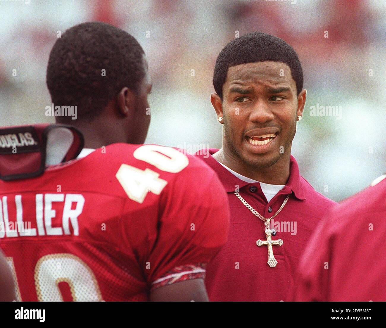 Florida State University's Peter Warrick (C) talks with teammate Cornelius  Collier (40) on the sidelines during the FSU-Miami game October 9. Warrick  and former Seminole teammate Lawrence Cole pleaded innocent to charges