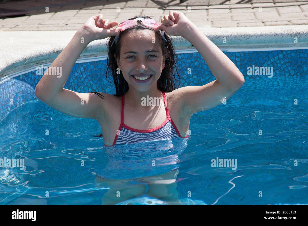 A portrait of an 11 year old girl in a swimming pool with swimming