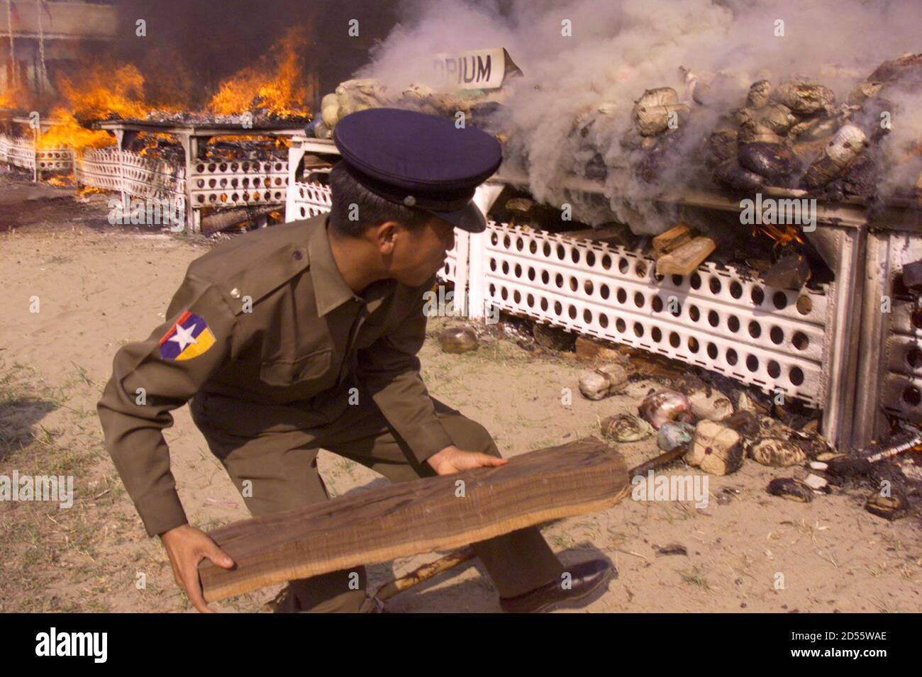 A Myanmar soldier puts a log of wood under bags of opium burnt in a police  compound in Yangon February 25. About four tonnes of raw opium, 430 kilos  of heroin, 34