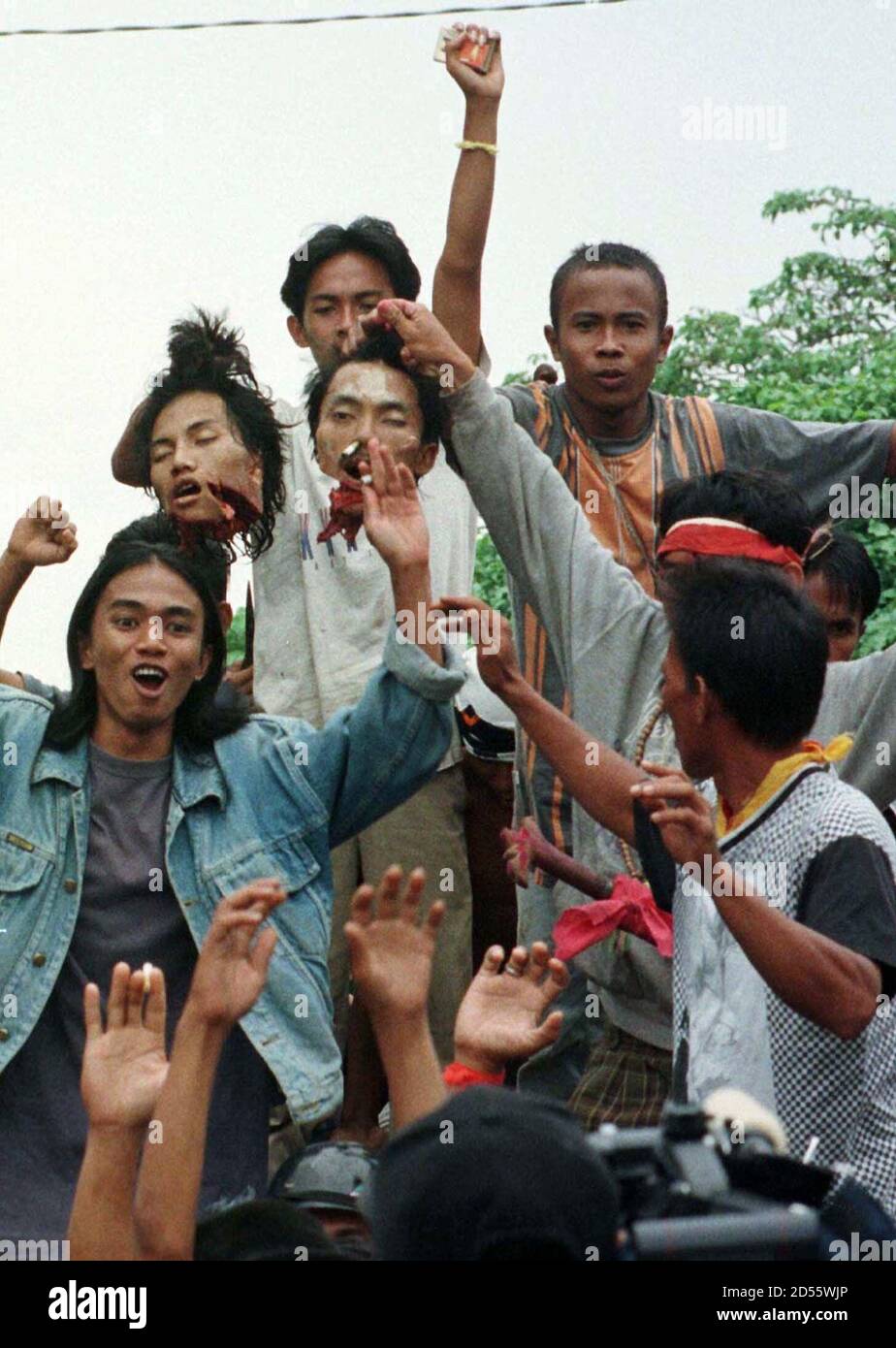 Kaw02 Indonesia Clashes Singkawang West Kalimantan Indonesia 20mar99 An Indigenous Malay Holds The Severed Heads Of Two Maduranese Men In The Village Of Tebas In West Kalimantan March 20 Ethnic Unrest Has Resulted In The Death Of