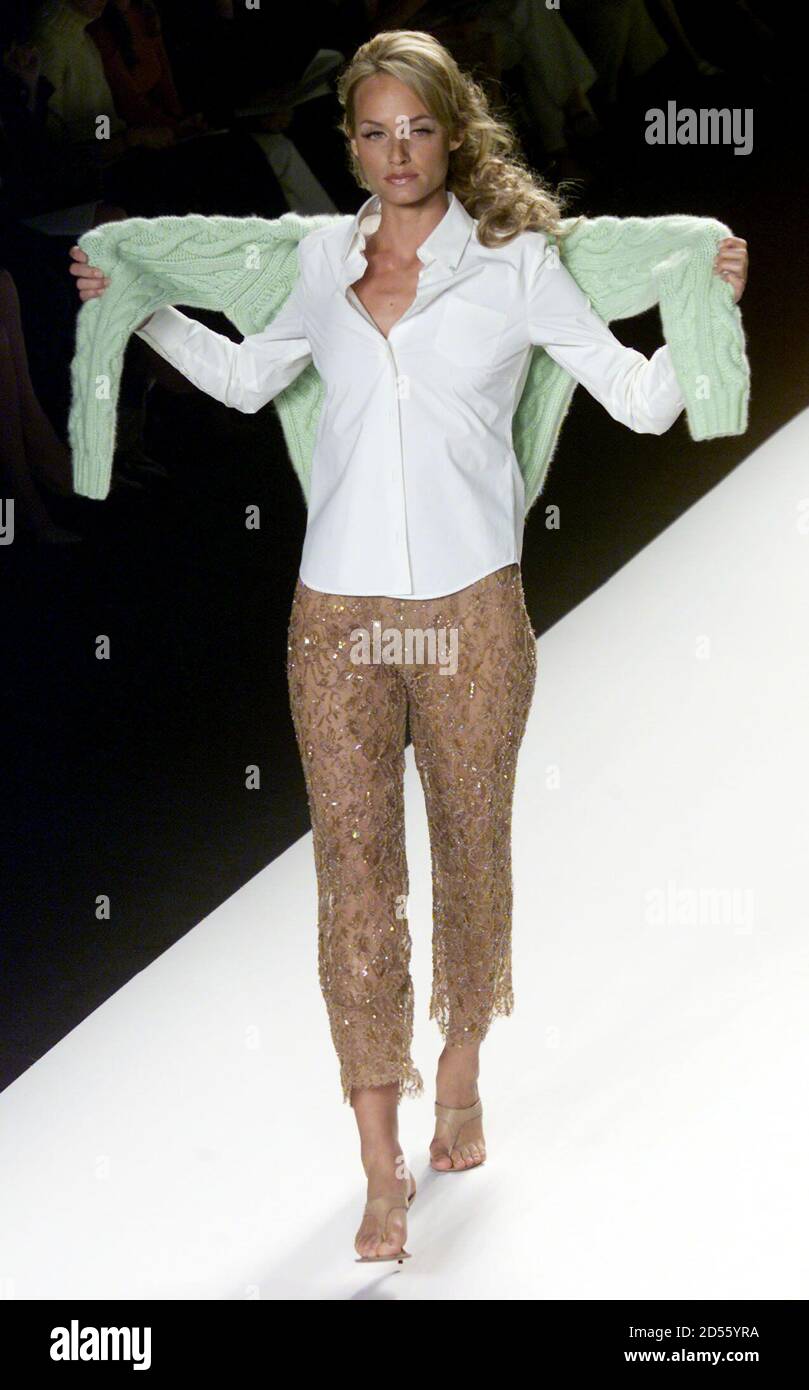 A model for designer Michael Kors wears a sheer beaded lace cropped slack  and white silk blouse as she carries a lime green knit sweater during the  showing of the Michael Kors