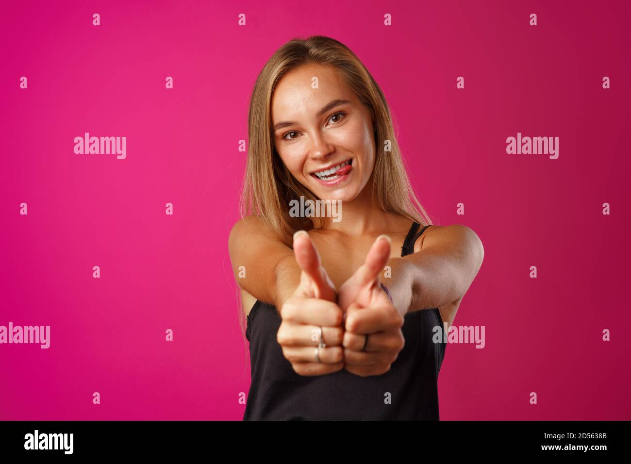 Portrait of a cheerful young woman showing thumbs up sign Stock Photo ...